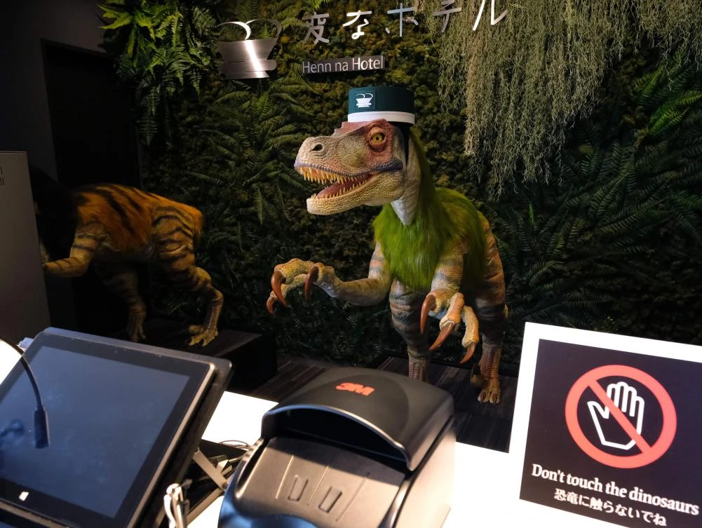 A robot dinosaur wearing a bellboy hats welcomes guests from the front desk at the Henn-na Hotel in Urayasu, suburban Tokyo on August 31, 2018. (AFP)