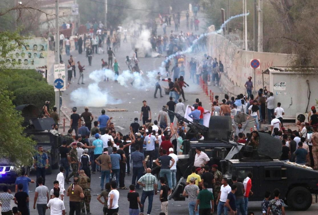 Iraqi protesters clash with security forces firing tear gas during a protest against the government and the lack of basic services, on August 31, 2018 in the southern city of Basra. (AFP)