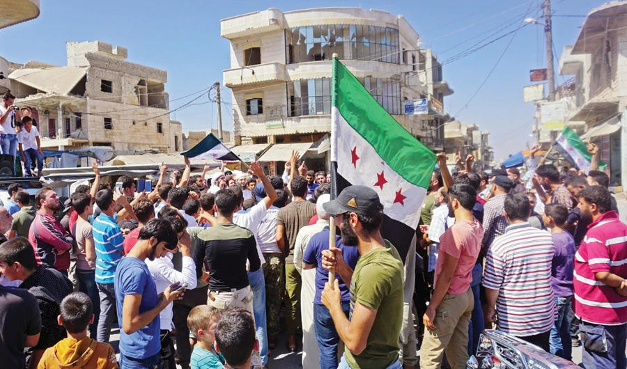 Syrians protest against the regime and its ally Russia in northern Idlib on Friday. (AFP)