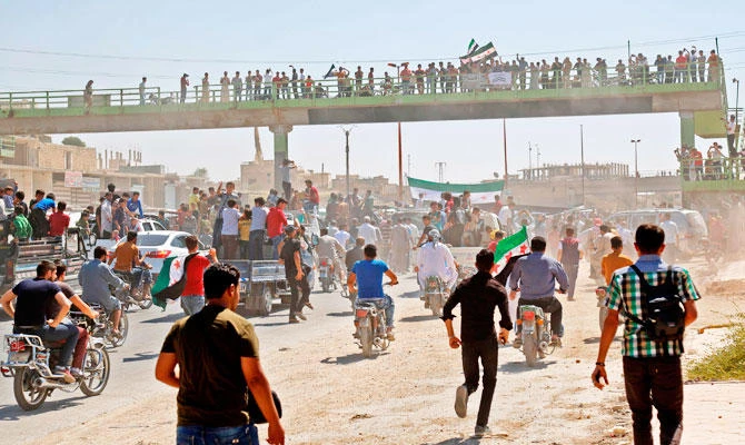 Syrians chant slogans and wave flags of the opposition as they protest against the regime and its ally Russia, in the rebel-held town of Maarrat al-Numan in the north of Idlib province on August 31, 2018. (AFP)