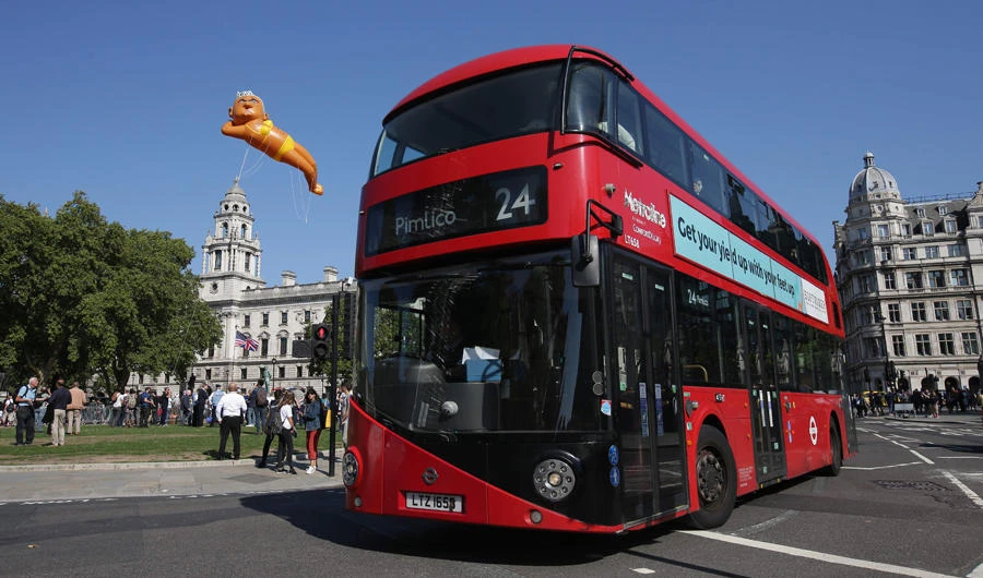A large balloon depicting London Mayor Sadiq Khan in a yellow bikini floats over an iconic London red bus as demonstrators gather in Westminster, in central London on September 1, 2018. (AFP / Daniel Leal-Olivas)