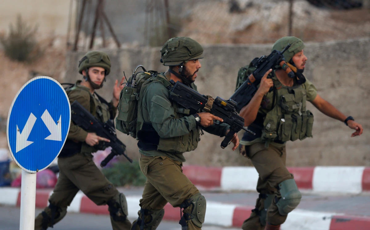 Israeli soldiers run near the scene where a Palestinian, who according to the Israeli military attempted to stab a soldier, was shot dead, in Hebron in the occupied West Bank September 3, 2018. (Reuters)