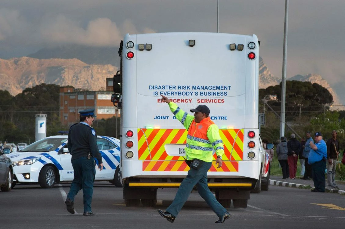 Traffic and police officers wave emergency vehicles into the Rheinmetall Denel munitions facility in Macassar, about 45km from the centre of Cape Town, after an explosion at the facility killed at least 8 people and injured more, on September 3, 2018. (AFP)
