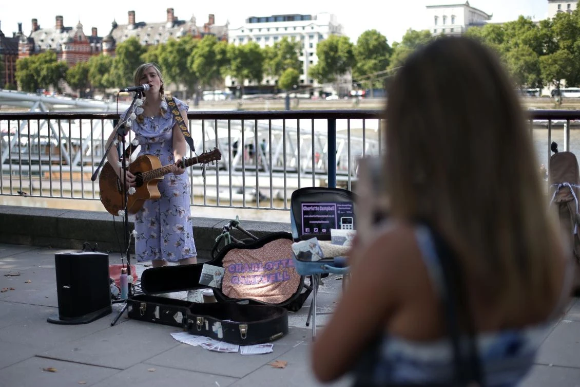 Busker Charlotte Campbell earns between five to 10 percent of her income from people tapping bank cards on her reader — set up through her phone to debit £2 at a time. (AFP)