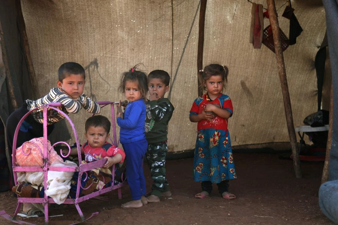 Syrian children stand outside a tent next to a metal crib at a camp for displaced civilians fleeing from advancing Syrian government forces, close to a Turkish military observation point near the village of Surman in the rebel-held northwestern Idlib province on September 5, 2018. (AFP)