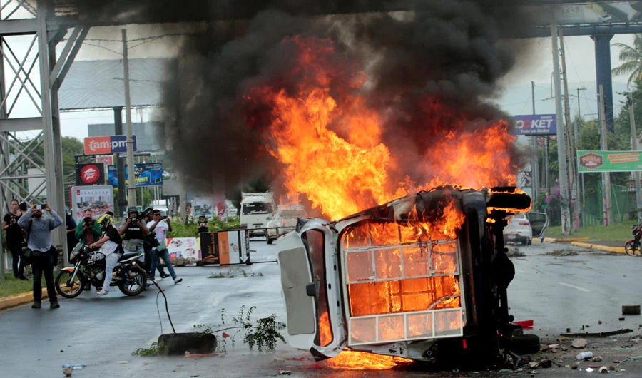 People take pictures of a burning police car during a protest against Nicaraguan President Daniel Ortega's government in Managua, Nicaragua, on September 2, 2018. (REUTERS/Oswaldo Rivas/File Photo)