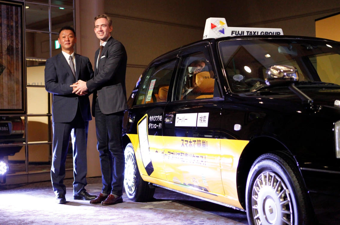 Uber’s Tom White and Fuji Taxi’s Hisashi Umemura. (Reuters)