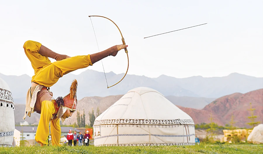 A woman shoots an arrow using her feet. (Getty Images)