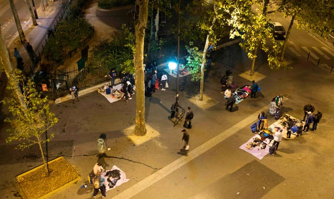 People sell and buy second-hand goods such as clothing, shoes, phones, phone chargers and DVDs at an illegal street vendor market, a semi-permanent market for the city's poor, on September 5, 2018 on Place de la Chapelle in Paris. (AFP)