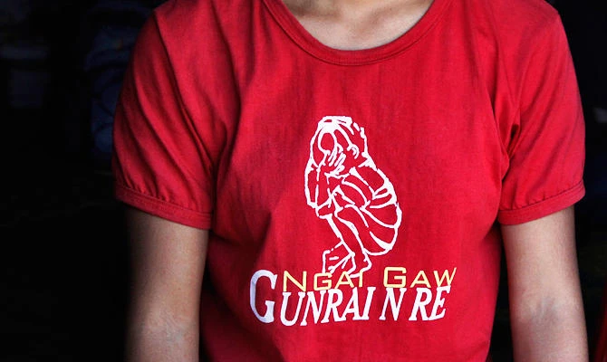 In this March 21, 2018, photo, wearing a T-shirt with words which read "I am not a commodity to sell," Marip Lu sits in her family's shelter in a refugee camp in northern Kachin State, Myanmar. (AP)