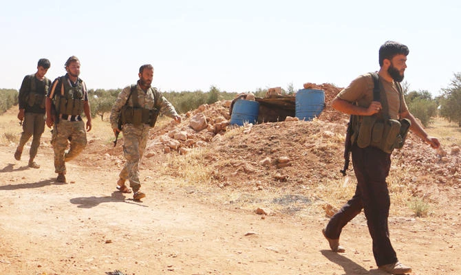 Syrian rebel fighters from the recently-formed "National Liberation Front" walk at an unknown location in the northern countryside of the Idlib province on September 5, 2018. (AFP)