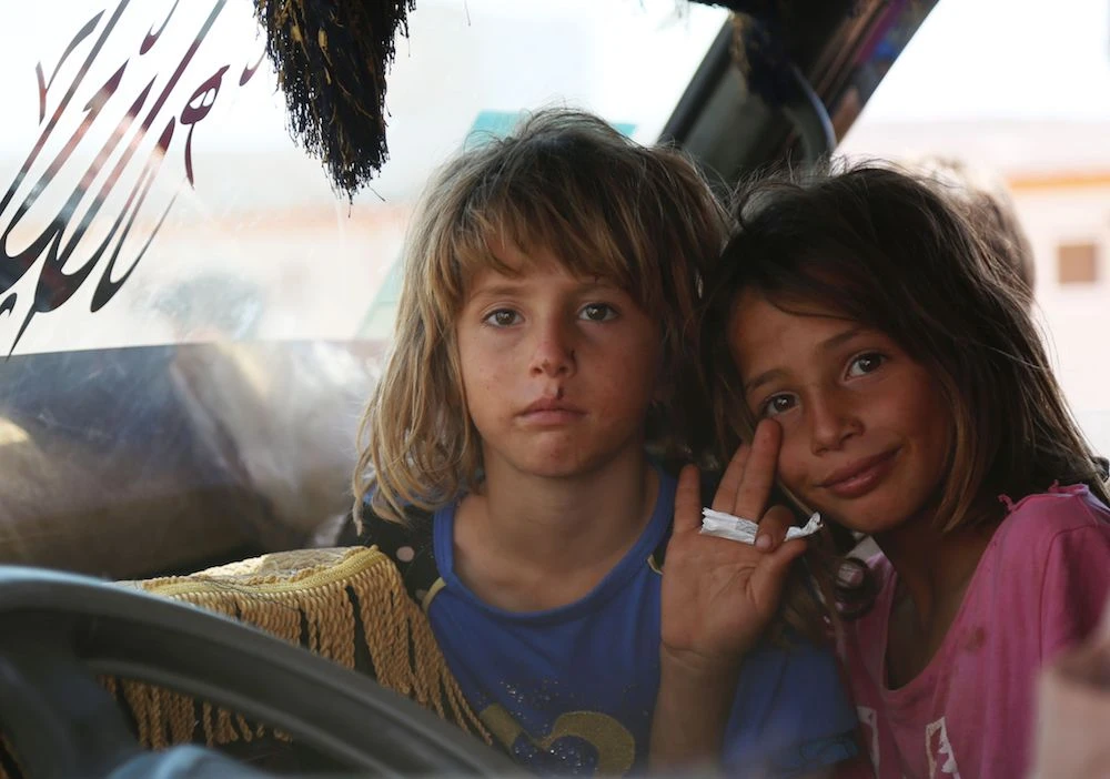 Displaced girls arrive at a camp in Kafr Lusin near the border with Turkey after fleeing fighting in Idlib. (AFP)