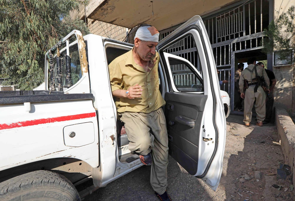 A wounded member of the Iranian Kurdistan Democratic Party (KDPI) steps out of a vehicle in their headquarters after a rocket attack in Koysinjaq, 100 kilometers east of Arbil, the capital of the autonomous Kurdish region of eastern Iraq, on September 8, 2018. (AFP / SAFIN HAMED)