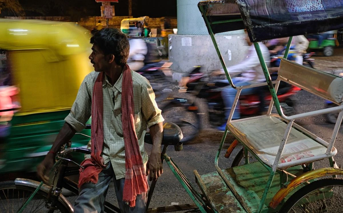 An Indian cycle rickshaw driver waits for customers next to a busy road in New Delhi. Facing a widening emerging market selloff, India’s rupee plumbed a fresh record low, with nationwide protests adding to the pressure. (AFP)