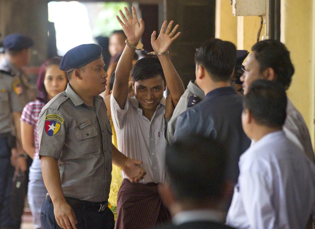 Reuters journalist Kyaw Soe Oo, center, is escorted by polices upon arrival at the court Monday, Sept. 3, 2018, in Yangon, Myanmar. (AP/Thein Zaw)