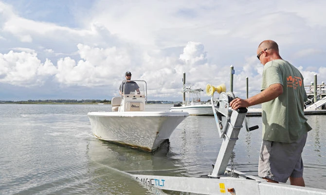 Nick Hobbs, left, and Randy Shaw, right, of Marine Warehouse Center, remove a customer's boat from the water in advance of Hurricane Florence in Wrightsville Beach, N.C., on Tuesday, Sept. 11, 2018. (AP)