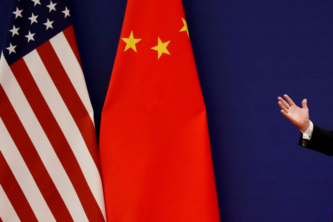 US President Donald Trump delivers his speech next to US and Chinese flags as he and Chinese President Xi Jinping meet business leaders at the Great Hall of the People in Beijing, China, November 9, 2017. (Reuters)