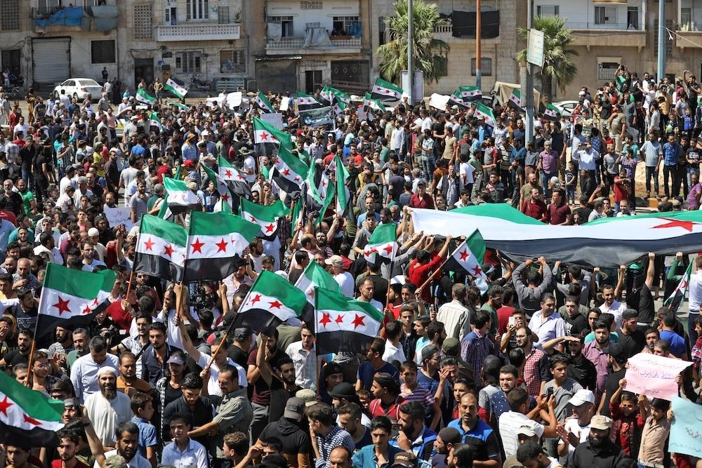Syrian protesters wave the flag of the opposition as they demonstrate against the regime and its ally Russia, in the rebel-held city of Idlib on September 7, 2018. (File Photo / AFP)