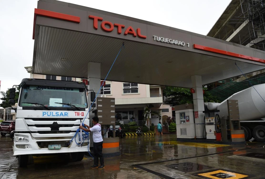 A worker anchors the roof of a fuel station to a mixer truck as Super Typhoon Mangkhut approaches the city of Tuguegarao, Cagayan province, north of Manila. (AFP)