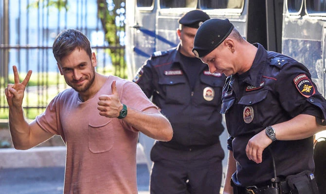 In this file photo taken on July 31, 2018 Member of the Pussy Riot punk group Pyotr Verzilov (L) gestures as he walks with police during a court hearing at a courthouse in Moscow, as members of the Russian protest-art group are accused of disturbing public order after invading the pitch during the World Cup final in Moscow. (AFP)