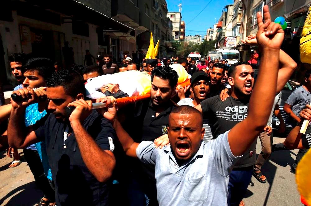 Palestinian mourners carry the body of 12-year-old Palestinian boy Shadi Abdel Aal during his funeral in Jabalia refugee camp in the northern Gaza Strip on September 15, 2018. (AFP)