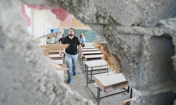 Palestinians inspect a classroom that was damaged in Israeli shelling. (Reuters)