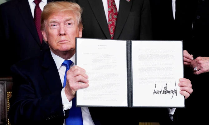 US President Donald Trump holds his signed memorandum on intellectual property tariffs on high-tech goods from China, at the White House in Washington, US, in this March 22, 2018 photo. (REUTERS)