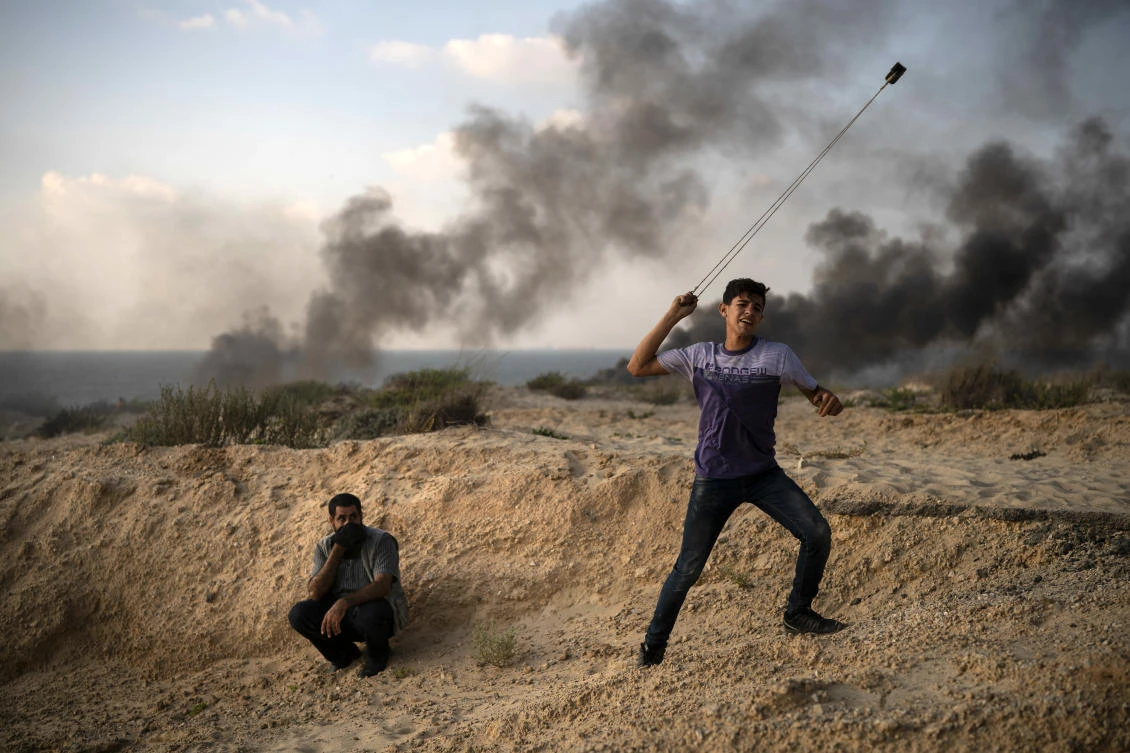 A young Palestinian protester hurls stones during a protest on the beach near the border with Israel in Beit Lahiya, northern Gaza Strip, Monday, Sept. 10, 2018. (File/AP/Felipe Dana)