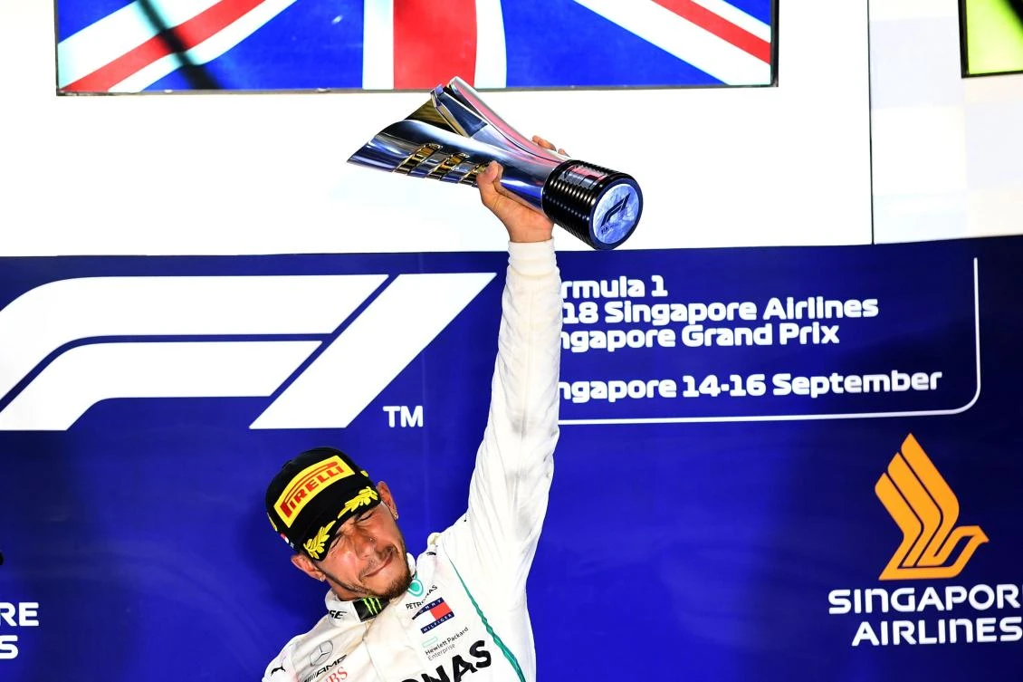 Mercedes' British driver Lewis Hamilton holds up the trophy on the podium after winning the Singapore Formula One Grand Prix at the Marina Bay Street Circuit in Singapore on September 16, 2018. (AFP)