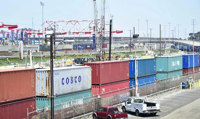 In this file photo taken on July 12, 2018 shipping containers, including those from COSCO, a Chinese state-owned shipping and logistics company await transportation on a rail line at the Port of Long Beach in Long Beach, California. (AFP)