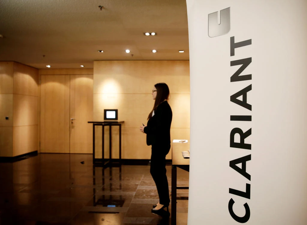 A woman stands next to logo of Swiss specialty chemicals company Clariant in Zurich. (Reuters)