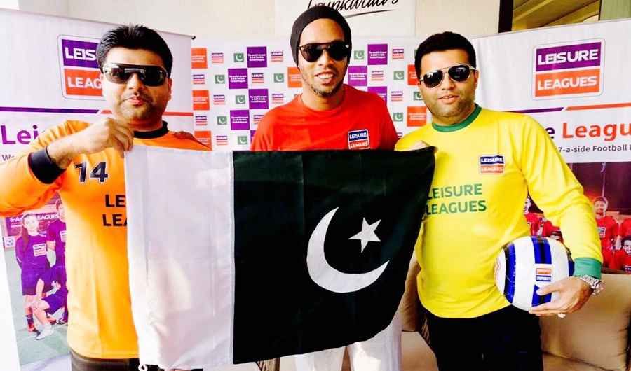 Brazilian football star Ronaldinho, center, and Shahzaib Mehmood Trunkwala, VP, ISF, right, pose with a Pakistani flag in Karachi. (Photo/supplied)