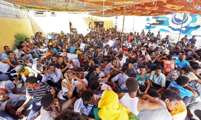 Illegal migrants sit inside the Ganzour shelter after being transferred from in the airport road due to fighting in the Libyan capital Tripoli on September 5, 2018. (AFP)