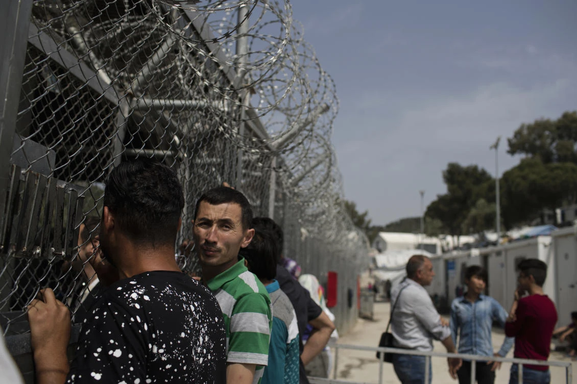 In this Friday, May 4, 2018 file photo migrants and refugees wait outside the European Asylum Support Service offices inside the camp of Moria on the northeastern Aegean island of Lesbos, Greece. (AP)