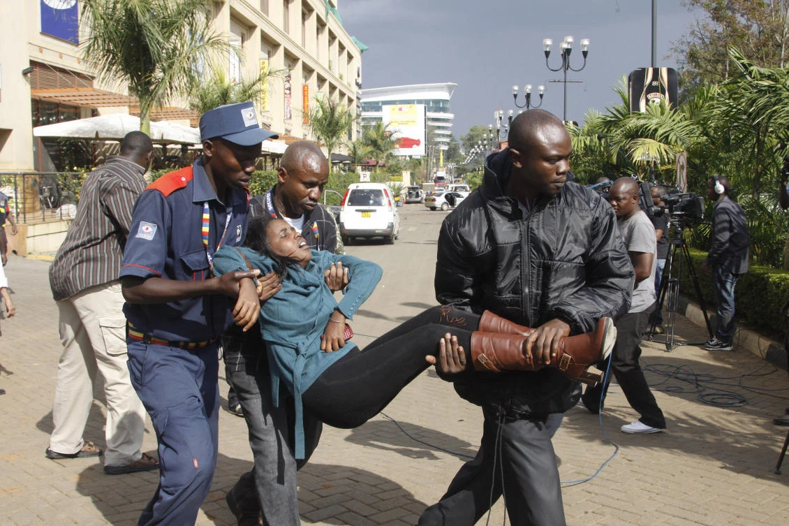 In this Saturday, Sept. 21, 2013, file photo, a security officer helps a wounded woman outside the Westgate Mall, after gunmen threw grenades and opened fire during an attack that left multiple dead and dozens wounded, in Nairobi, Kenya. (AP)