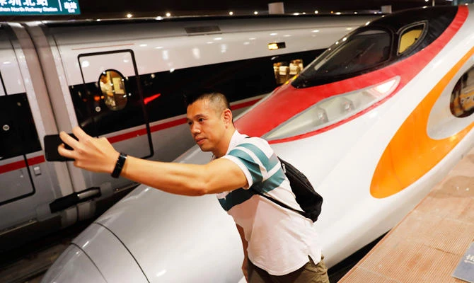 A passenger takes a selfie next to the first train of the Guangzhou-Shenzhen-Hong Kong Express Rail Linkas after it arrived in Shenzhen on September 23, 2018. (AFP)