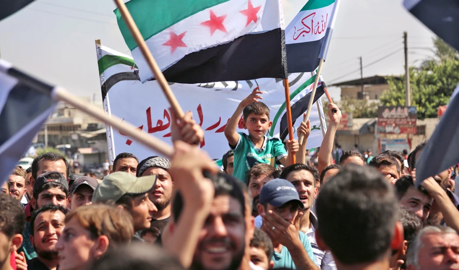 Syrians wave flags during a demonstration in the rebel-held northern Syrian city of Idlib on Sept. 21, 2018, in support of the agreement between Turkey and Russia, to avert an assault on Syria's last major rebel stronghold. (AFP)