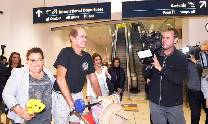 Australian filmmaker James Ricketson, third left, walks with his daughter Roxanne Holmes, second left, after his arrival at Sydney International Airport, Sunday, Sept. 23, 2018. (AP)