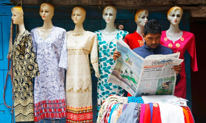 A Nepalese roadside vendor reads the news in Kathmandu, Nepal, Friday, Sept. 21, 2018. (AP)