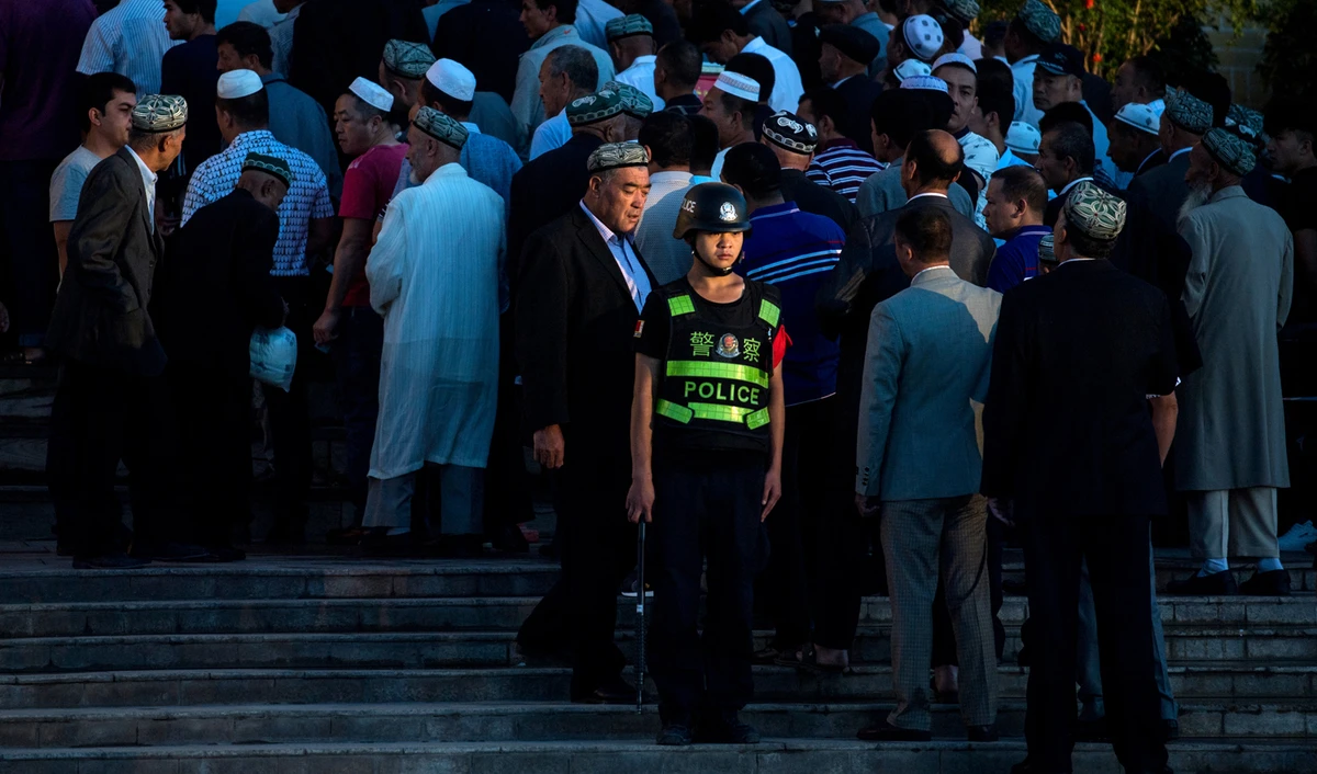 This file photo shows a policeman standing guard as Muslims arrive for the Eid al-Fitr morning prayer at the Id Kah Mosque in Kashgar in China's Xinjiang Uighur Autonomous Region on June 26, 2017. (AFP)