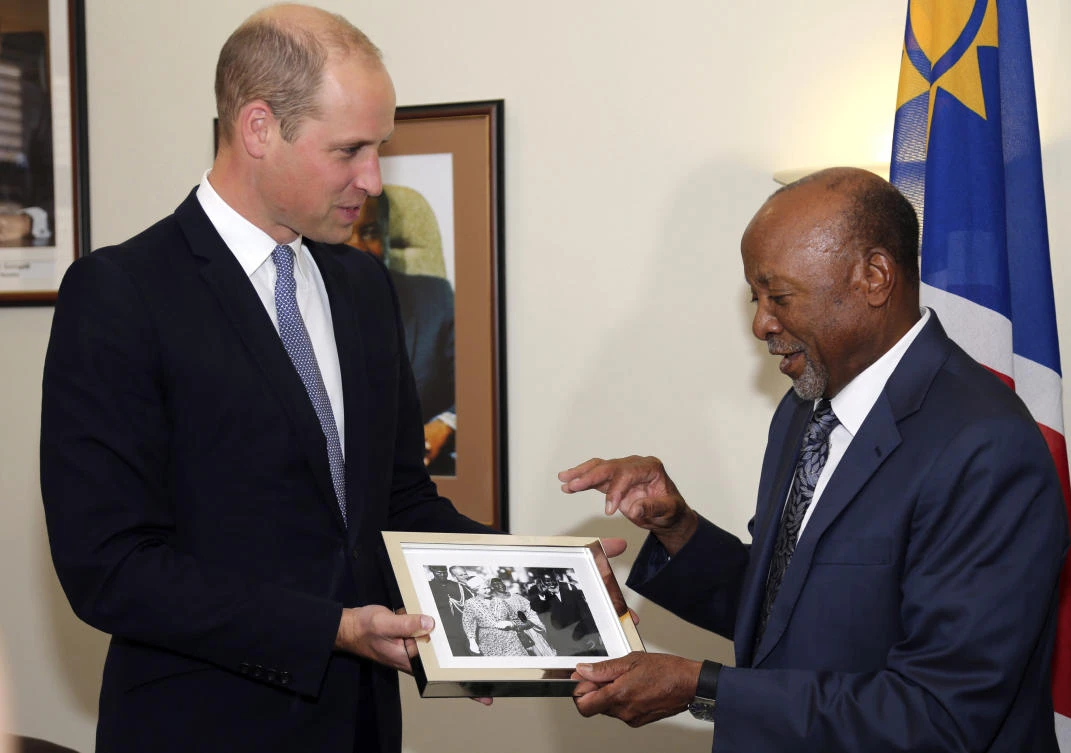 Britain's Prince William, left, presents Namibia's Vice President Nangolo Mbumba with a photo of his grandmother Queen Elizabeth with Namibia's first President, Sam Nujoma, in Windhoek, Namibia, Monday Sept. 24, 2018. (AP)