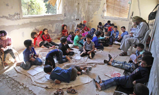 Displaced Syrian children attend class at a makeshift school in the village of Muhandiseen, in the south western countryside of the Aleppo province, on September 24, 2018. (AFP)
