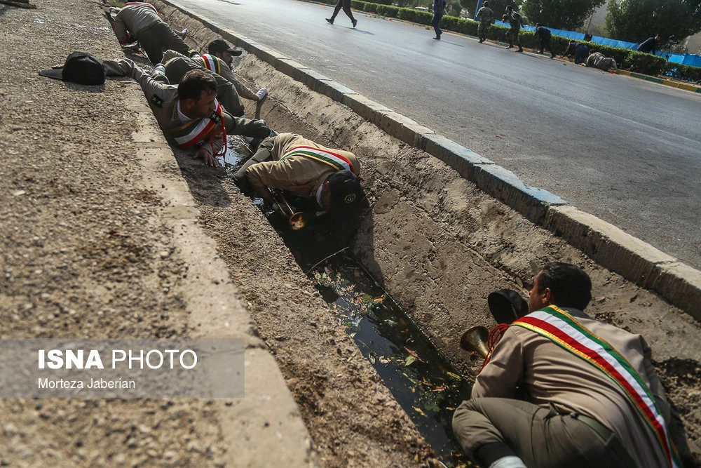 Soldiers take cover during the attack on a parade in southern iran on Saturday. (via Reuters)