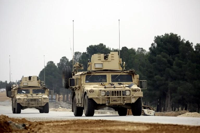 US forces, who have been in Syria since late 2014, drive armored vehicles as they patrol the roads surrounding Manbij north of Syria. (AFP)