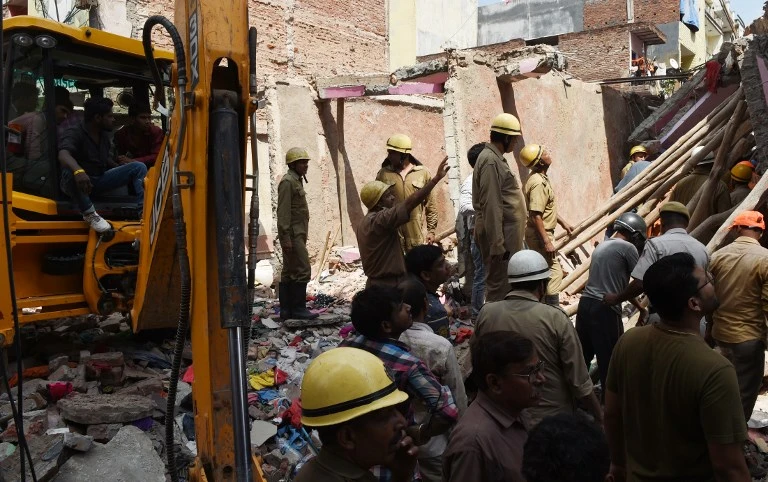 Rescuers comb the wreckage on an apartment block which collapsed in New Delhi. (AFP)