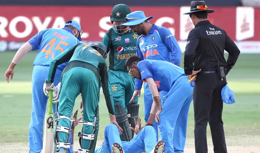 Indian and Pakistani players check on India's Hardik Pandya, on ground, after he fell during the one day international cricket match of Asia Cup between India and Pakistan in Dubai, UAE, on Sept. 19, 2018. (AP Photo/Aijaz Rahi)