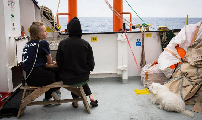A handout photo released on September 29, 2018 by SOS Mediterranee shows a rescuer talking a migrant on September 26 aboard the Aquarius rescue ship run by non-governmental organisations (NGO) "SOS Mediterranee" and "Medecins Sans Frontieres" (Doctors without Borders) in the search and rescue zone off the coast of Libya, in the Mediterranean Sea. (AFP)