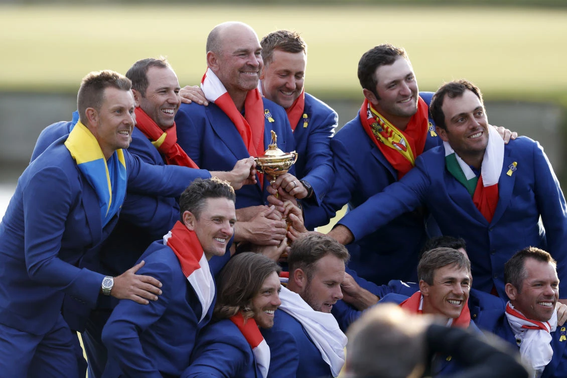 Europe team captain Thomas Bjorn is surrounded by his team as they pose with the trophy after the European team won the 2018 Ryder Cup in Paris. (AP)