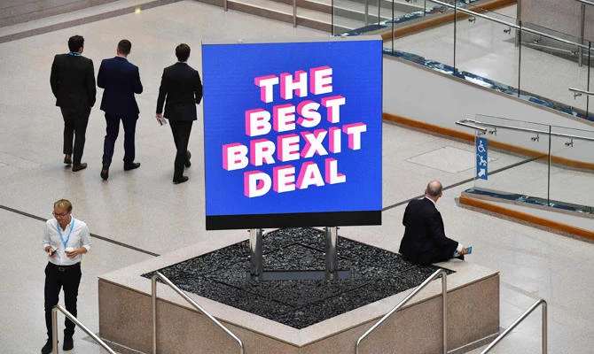 Delegates are seen near a sign that reads "The Best Brexit Deal" at the venue on the first day of the Conservative Party Conference 2018 at the International Convention Centre in Birmingham, on September 30, 2018. (AFP)