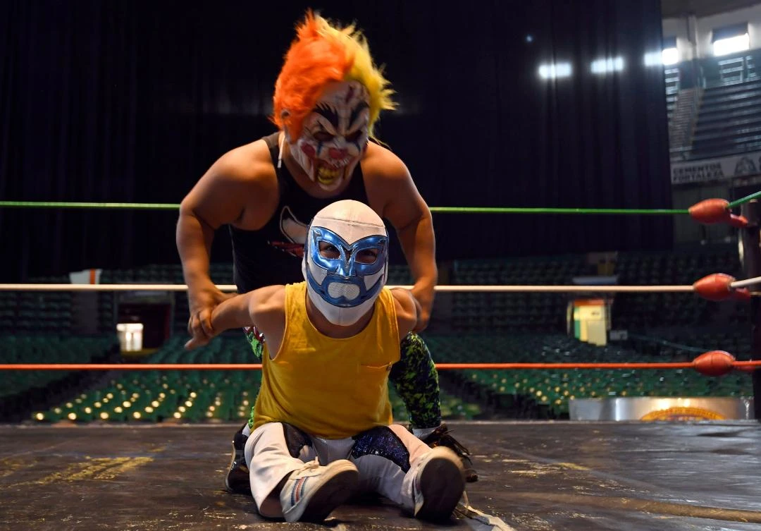 Dwarf fighters Microman (front) and Chamuel take part in a training session at the Arena Mexico, in Mexico City on July 18, 2018. "Microstars" is a show that mixes sport, circus and collective catharsis in what Mexicans call "fights". / AFP / ALFREDO ESTRELLA